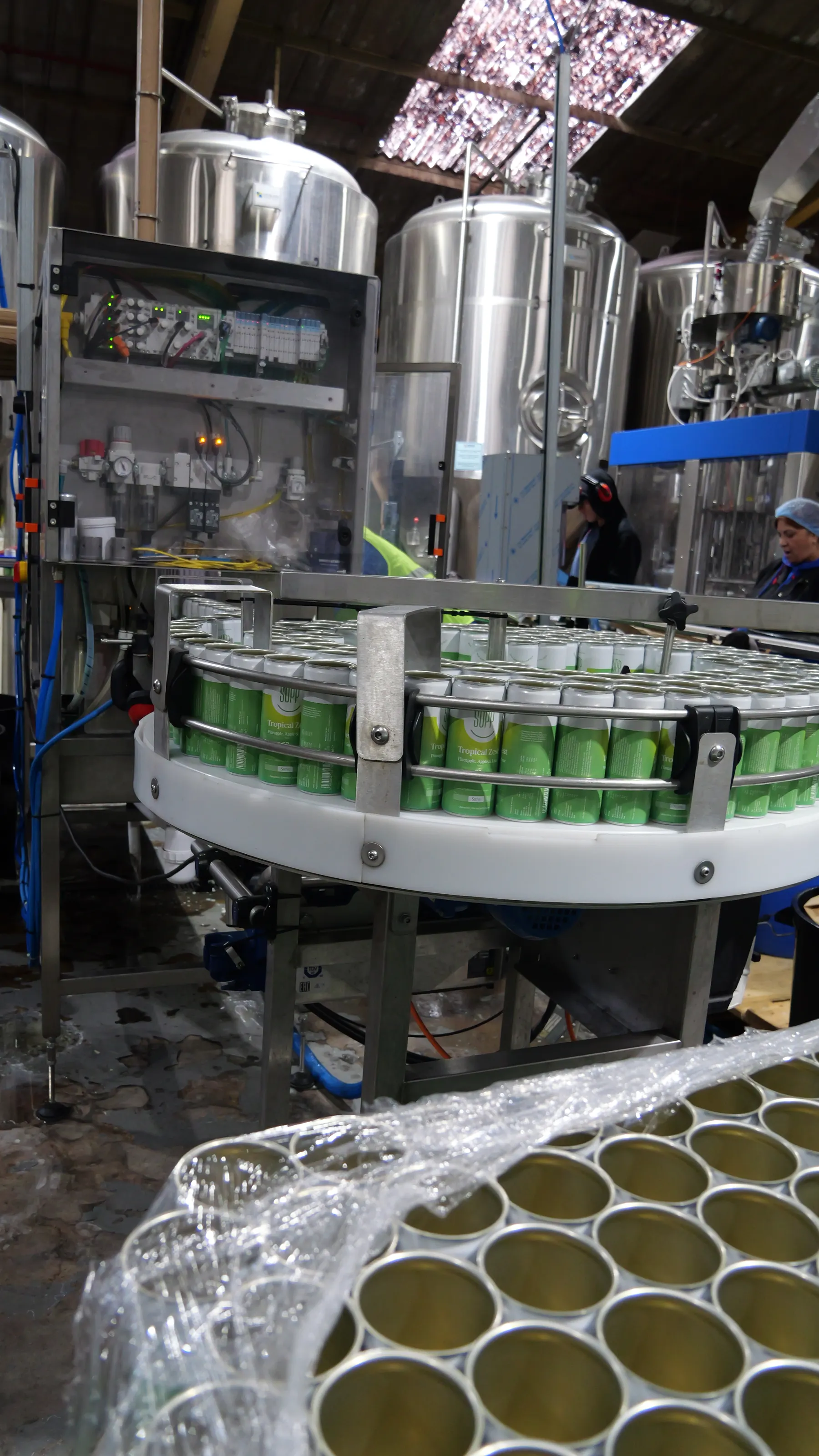 Wide view of the canning hall with steel tanks, a rotary table of Supp cans and wrapped pallets