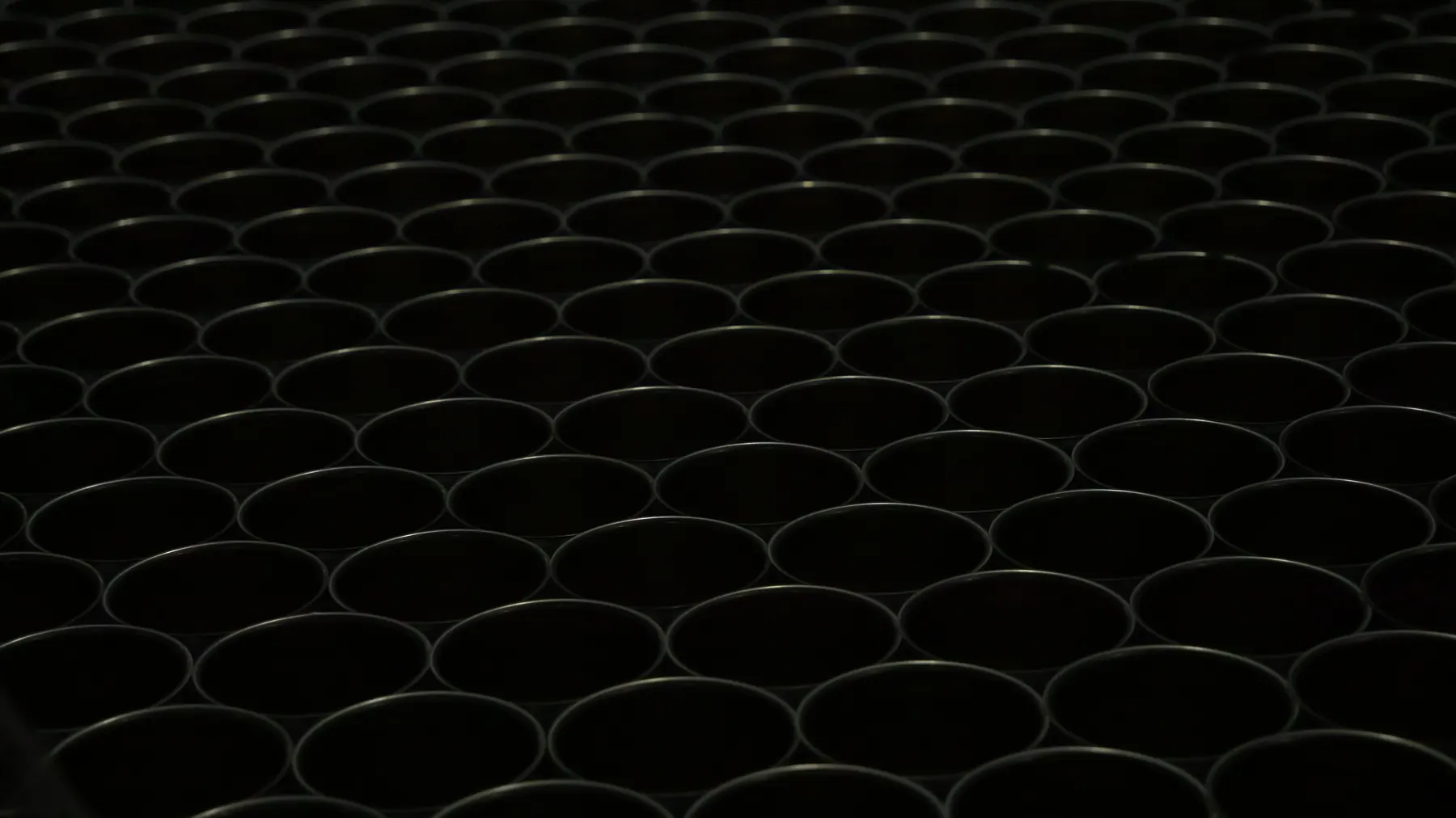 Low light pattern of empty open can tops in rows
