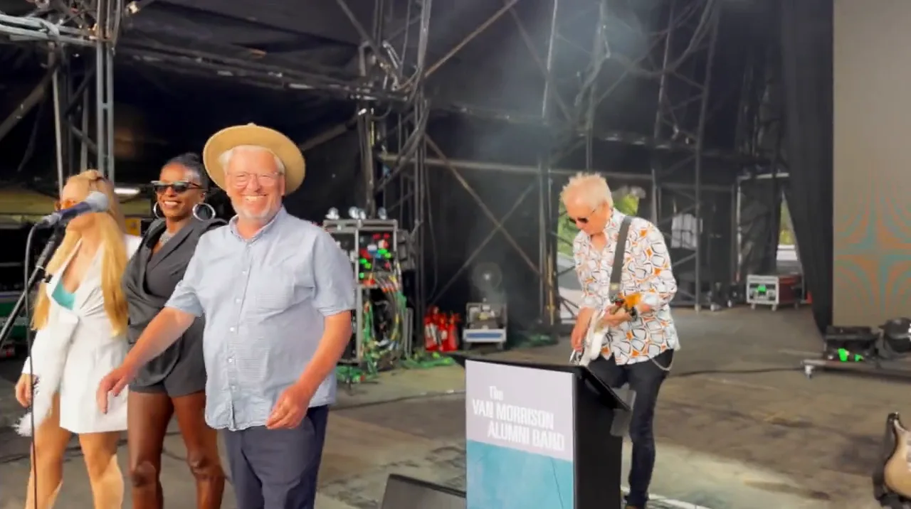 The band smiling and taking the applause together at the end of the set